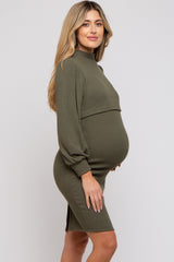 woman wearing an olive green ribbed maternity dress with long sleeves and a fitted silhouette, showcasing her baby bump