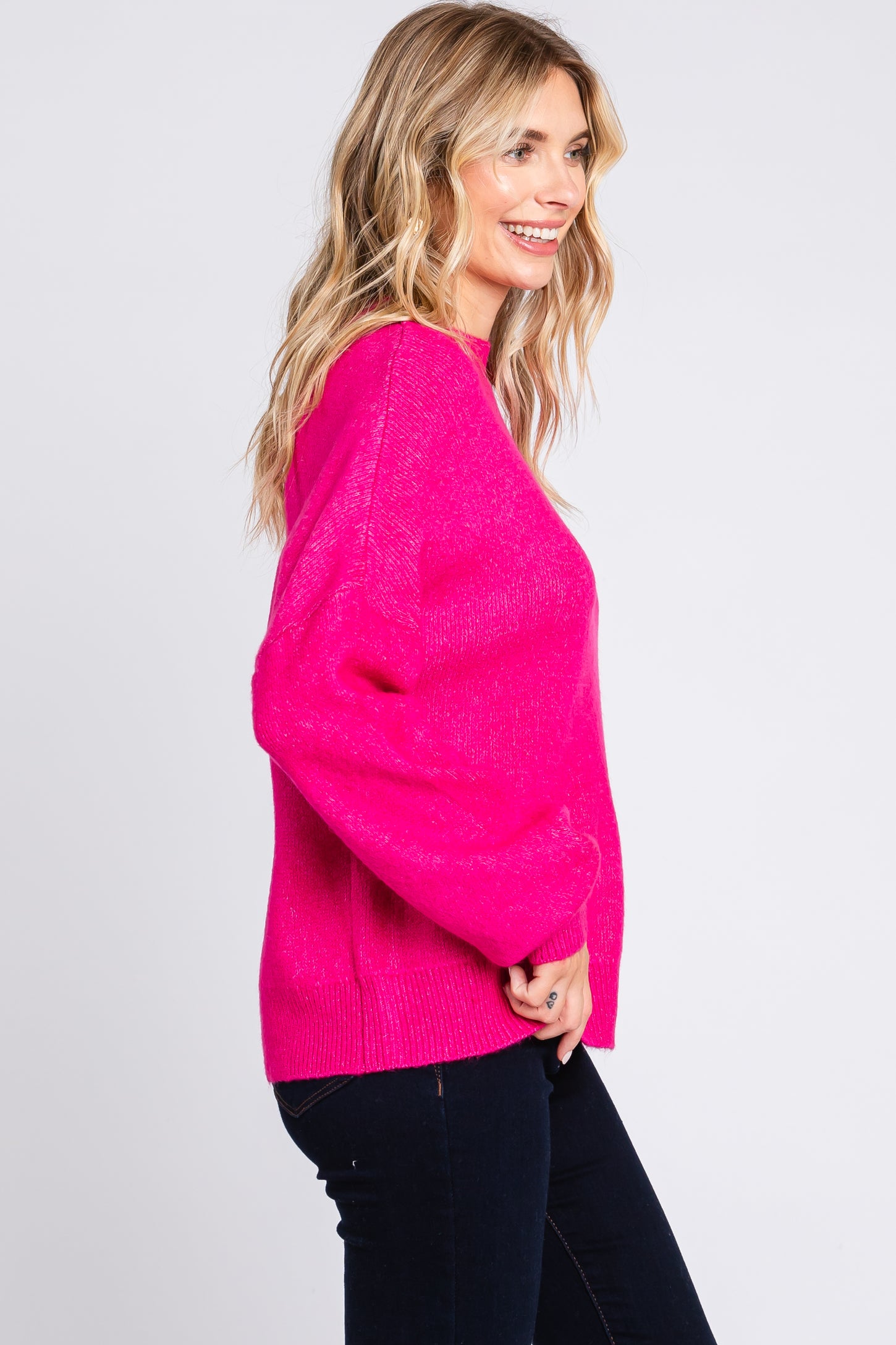 woman wearing a bright pink oversized sweater with long sleeves and a relaxed fit