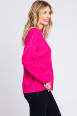 woman wearing a bright pink oversized sweater with long sleeves and a relaxed fit