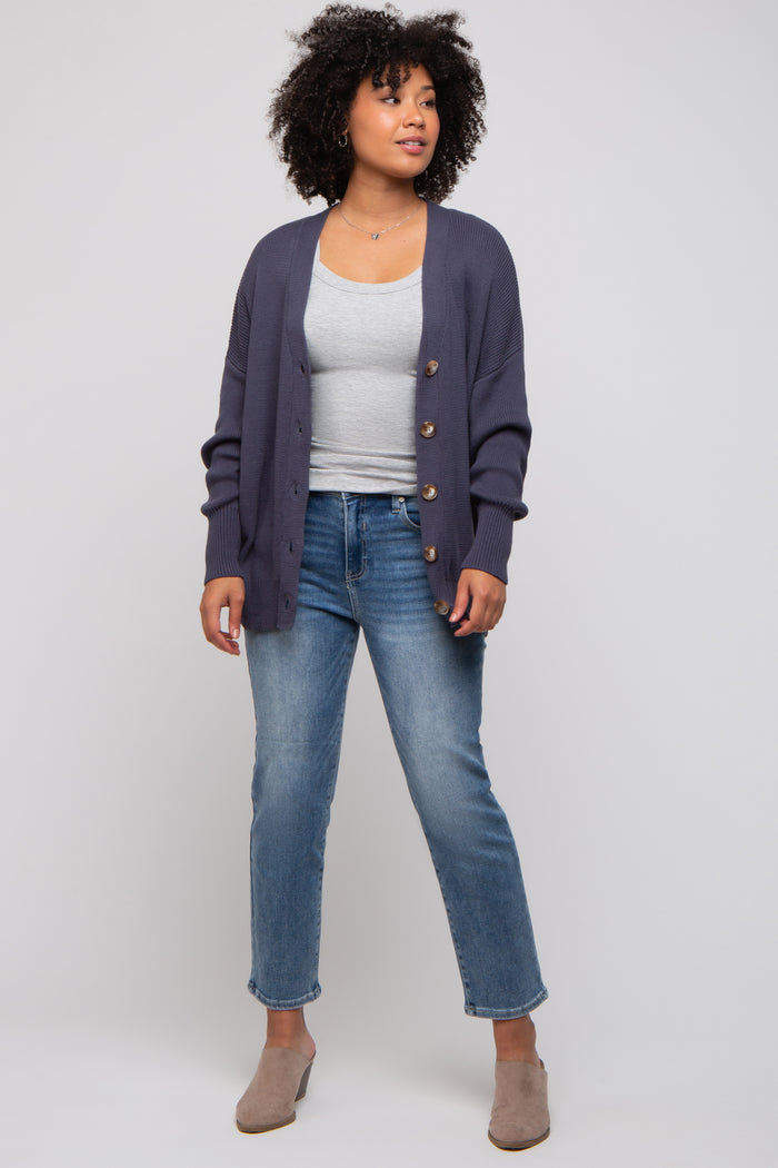 woman wearing a grey tank top, navy cardigan, and light blue jeans with beige mules