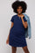 woman wearing a navy blue short sleeve t-shirt dress and holding a denim jacket over her shoulder