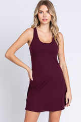 woman wearing a burgundy sleeveless swing dress with a scoop neckline