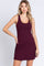 woman wearing a burgundy sleeveless swing dress with a scoop neckline