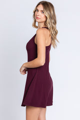 woman wearing a burgundy sleeveless dress with a relaxed fit and a slight flare at the hem