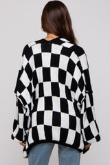 woman wearing a black and white checkered maternity sweater, with loose fit and open sleeves, viewed from the back