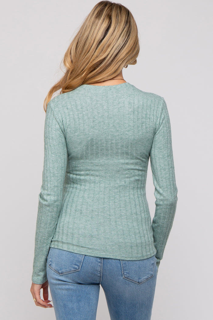 woman wearing a light green ribbed maternity top, seen from the back, paired with blue jeans