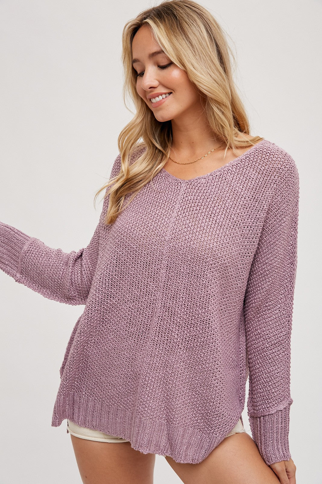 woman wearing a light purple oversized knit sweater with a scoop neckline and long sleeves