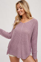 woman wearing a light purple oversized knit sweater with a scoop neckline and long sleeves