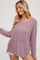 woman wearing a light purple oversized knit sweater with a scoop neckline and long sleeves