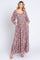 woman wearing a long floral maxi dress with a square neckline and puffed sleeves, featuring pockets