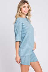 woman wearing a light blue short sleeve ribbed knit top and matching shorts