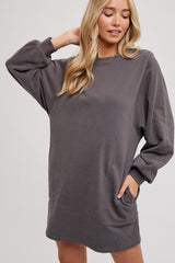 woman wearing a gray oversized fleece sweatshirt dress with long sleeves and front pockets