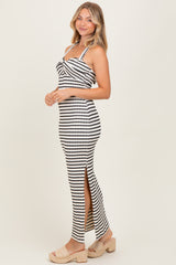 woman wearing a black and white striped maxi dress with side slits and a twist front detail.