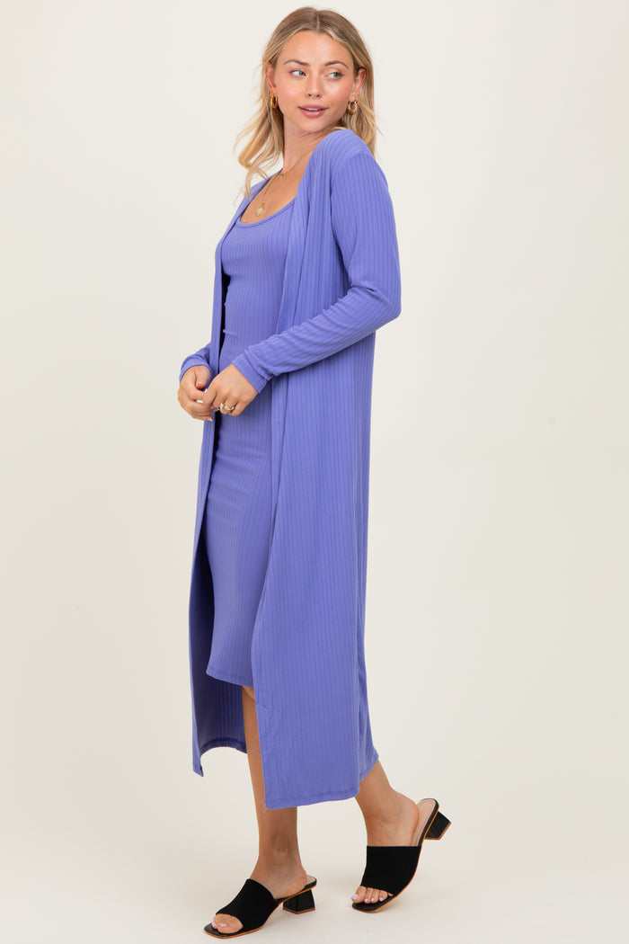 woman wearing a lavender ribbed long cardigan over a matching spaghetti strap dress and black slide sandals