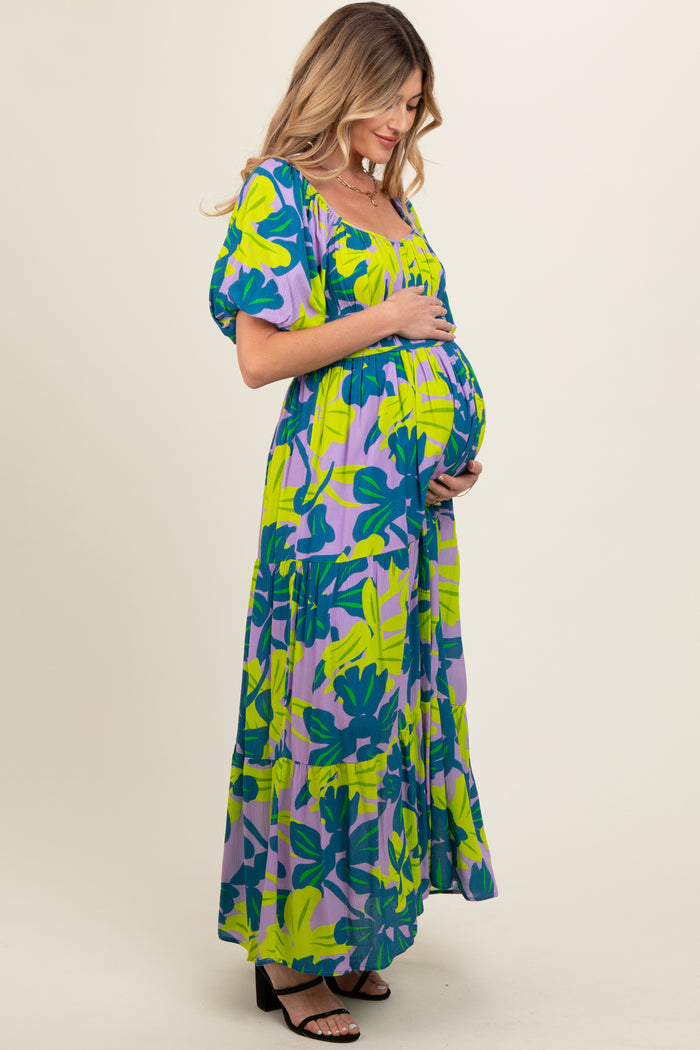 woman wearing a colorful floral maternity maxi dress and showcasing her baby bump