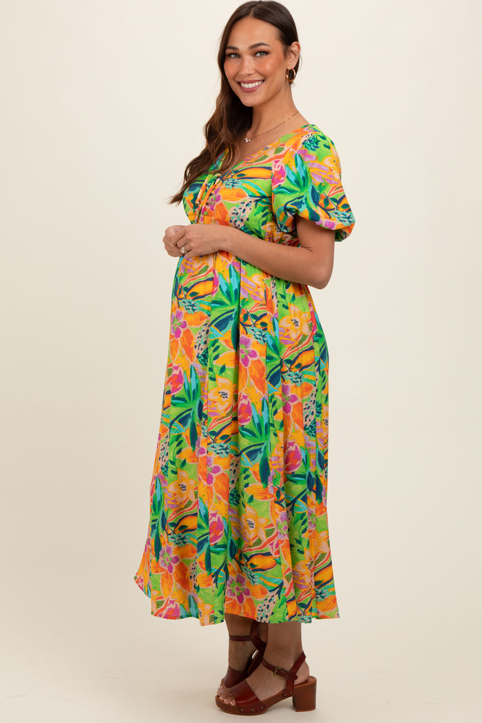 woman wearing a colorful floral maternity dress with short puff sleeves and a baby bump visible