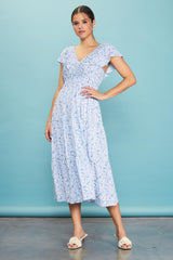 woman wearing a blue floral midi dress with ruffled sleeves and a v-neckline