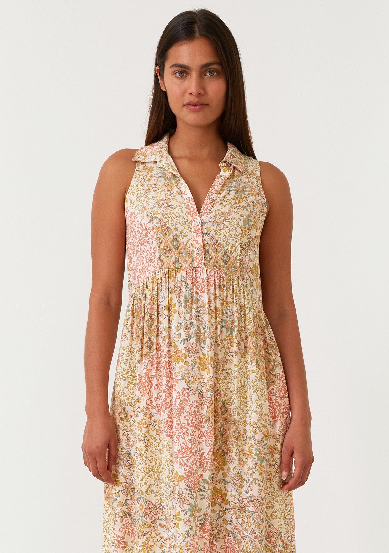 woman wearing a floral patterned sleeveless midi dress with a collared neckline and button-down front