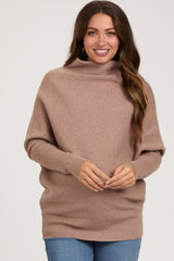 woman wearing a taupe oversized maternity sweater with a cowl neck and long sleeves
