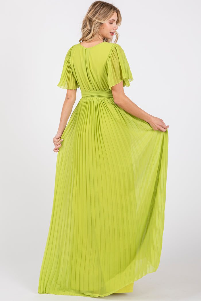 woman wearing a bright lime green pleated maxi dress with short flutter sleeves and a cinched waist