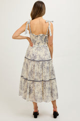 woman wearing a floral print maternity maxi dress with tie shoulder straps and a tiered skirt, shown from the back