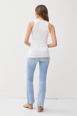 woman wearing a white ribbed tank top and light blue flared jeans, viewed from the back