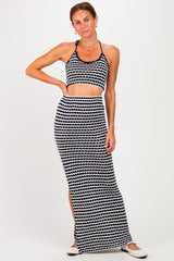 woman wearing a black and white patterned crop top and matching maxi skirt with a side slit
