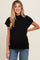 woman wearing a black short sleeve maternity top and showing her baby bump while smiling