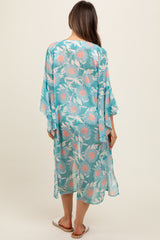 woman wearing a sheer turquoise maternity kimono with floral print, shown from the back