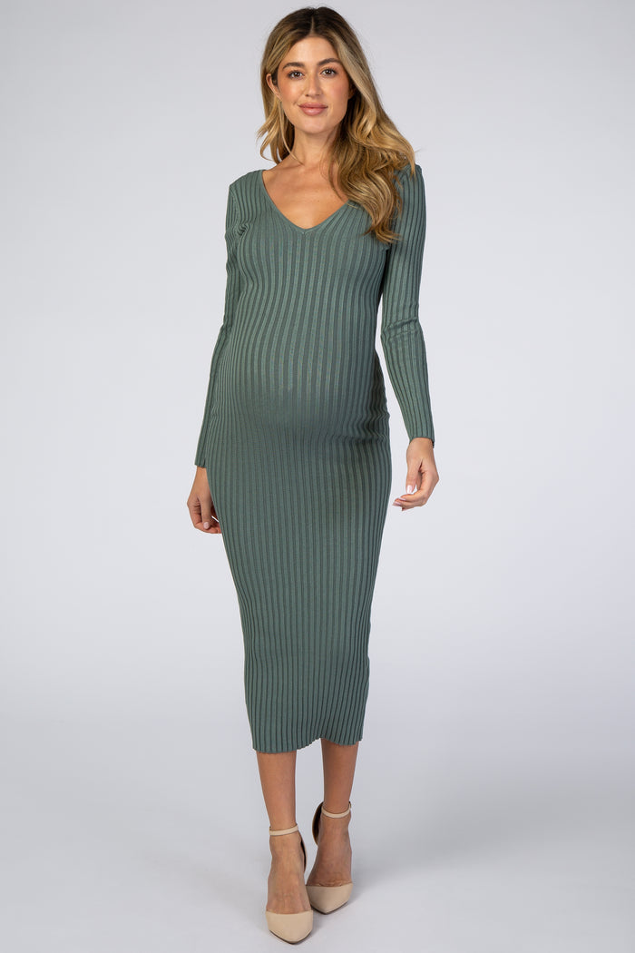 woman wearing a green ribbed maternity midi dress with a v-neck and long sleeves, showcasing her baby bump