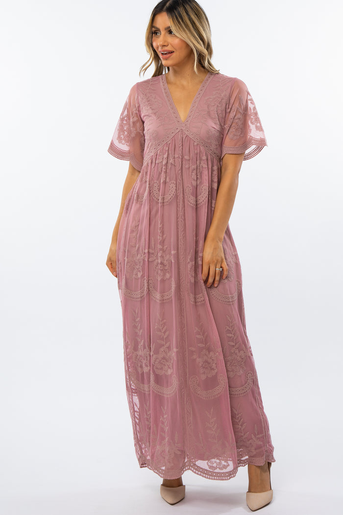 woman wearing a mauve floral lace maxi dress with short flutter sleeves and a v-neckline
