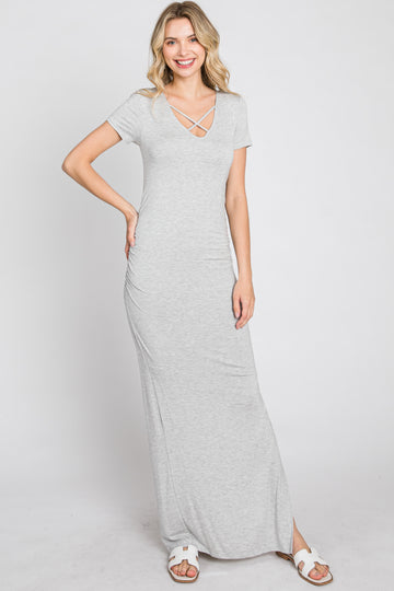 woman wearing a grey short sleeve maxi dress with a crisscross v-neckline and white sandals