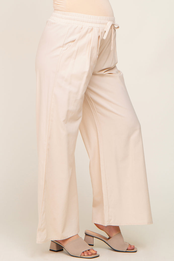woman wearing beige wide leg maternity pants with drawstring waist and matching block heel sandals