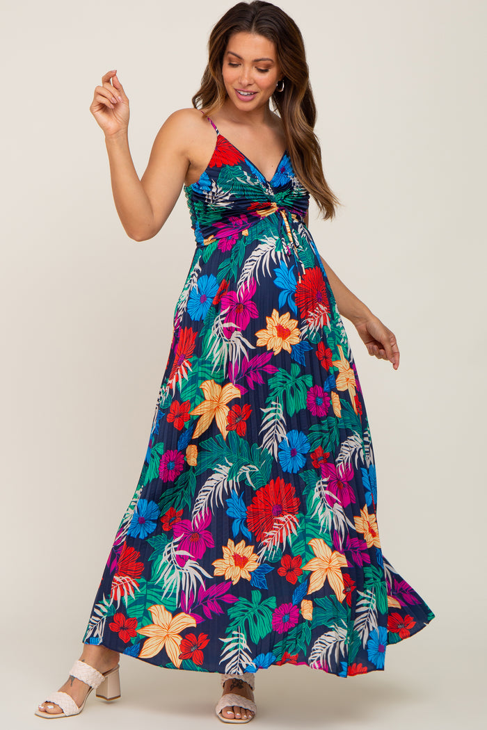 woman wearing a colorful floral maxi maternity dress with a twist front detail and a visible baby bump