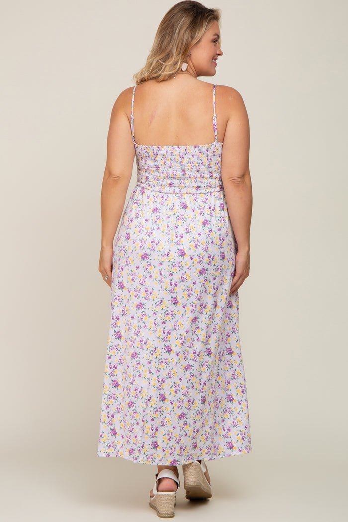 Back view of a woman wearing a purple and yellow floral smocked maxi dress with spaghetti straps and wedge sandals