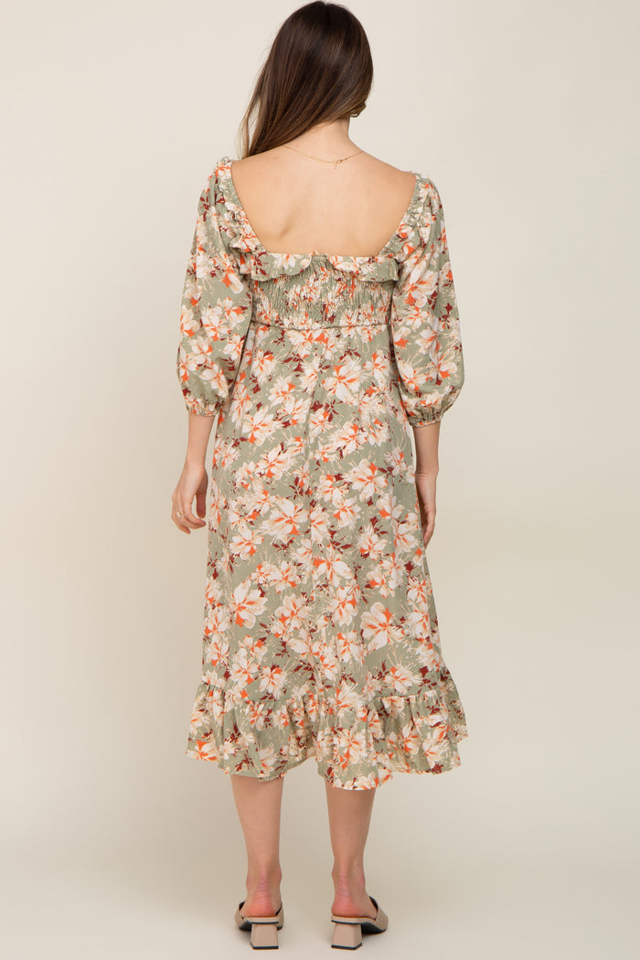 woman wearing a floral maternity dress with a smocked back and ruffled hem, showing her pregnant belly